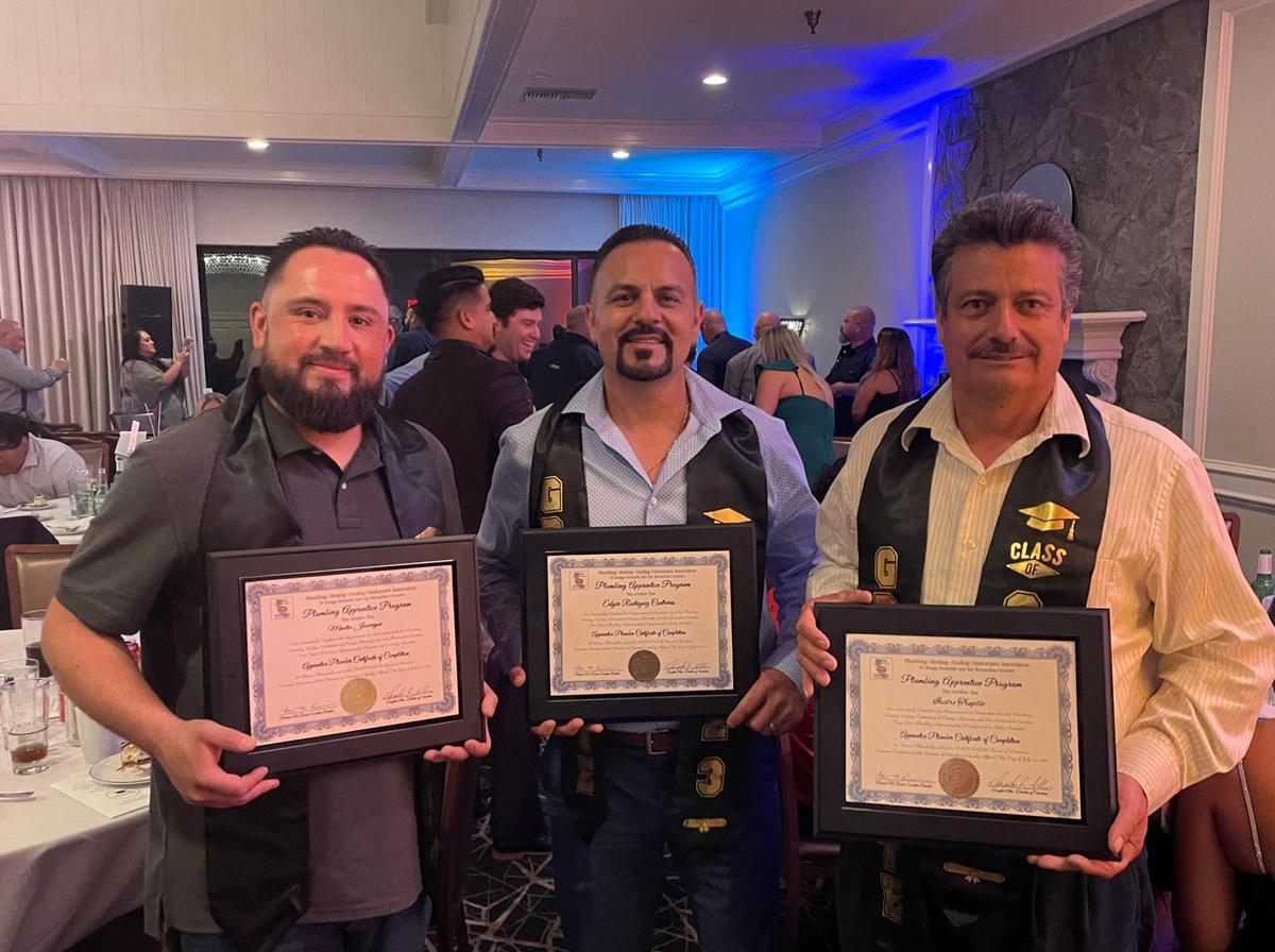 3 members of the team showing awards