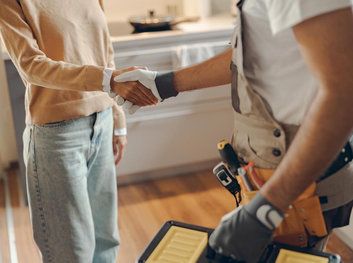 A homeowner and technician shaking hands