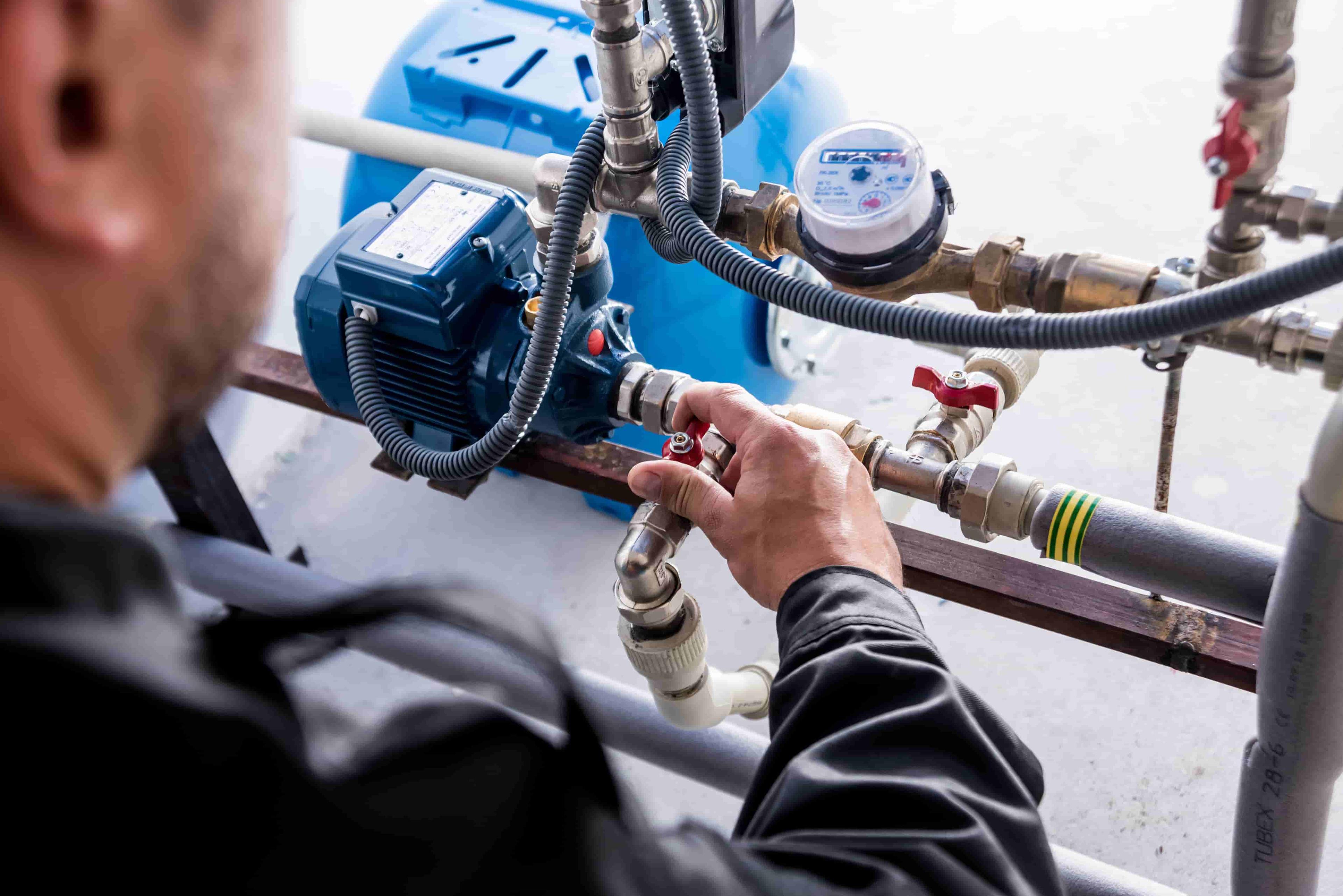 Commercial plumber checking water supply system nodes to maintain pipe performance.